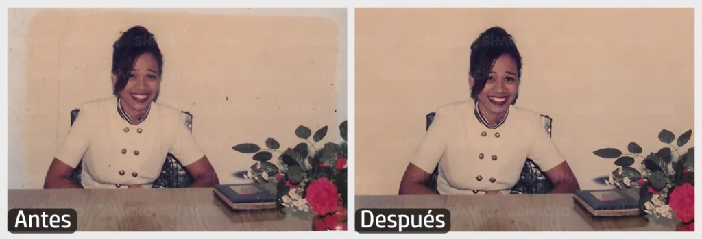 Mujer joven sonriendo, sentada frente a un escritorio en el que hay un florero y un libro.